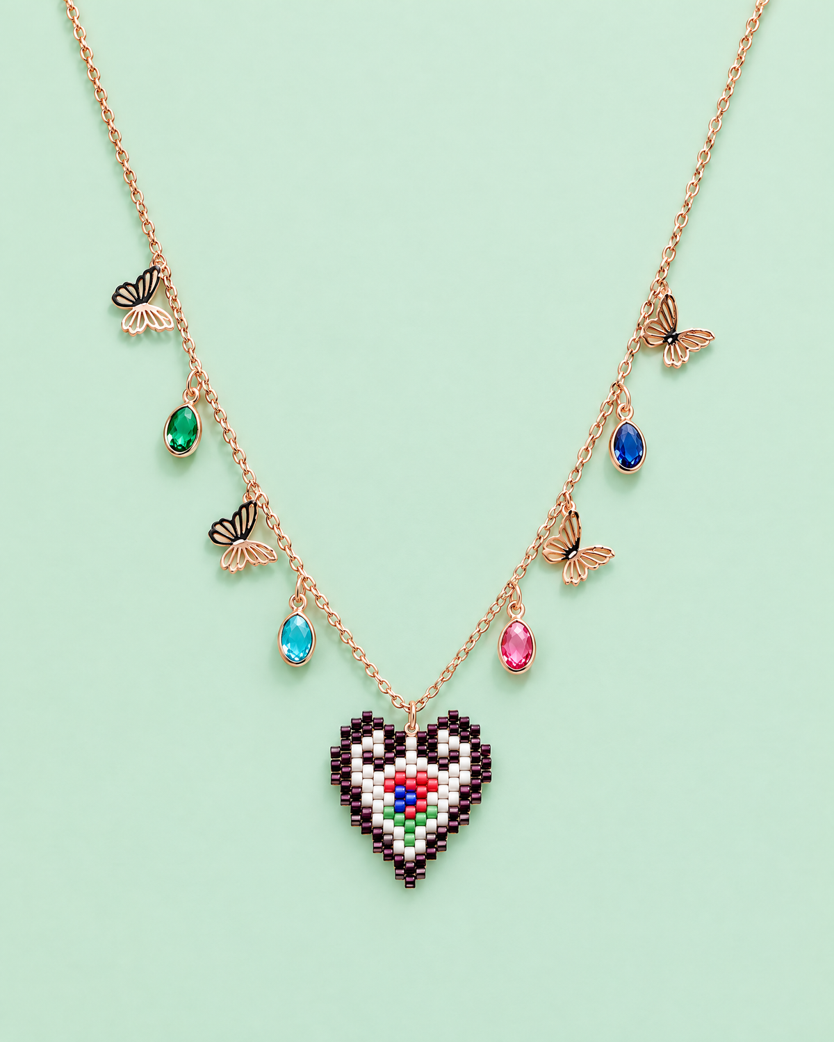 Butterfly Heart Charm Necklace on mint background