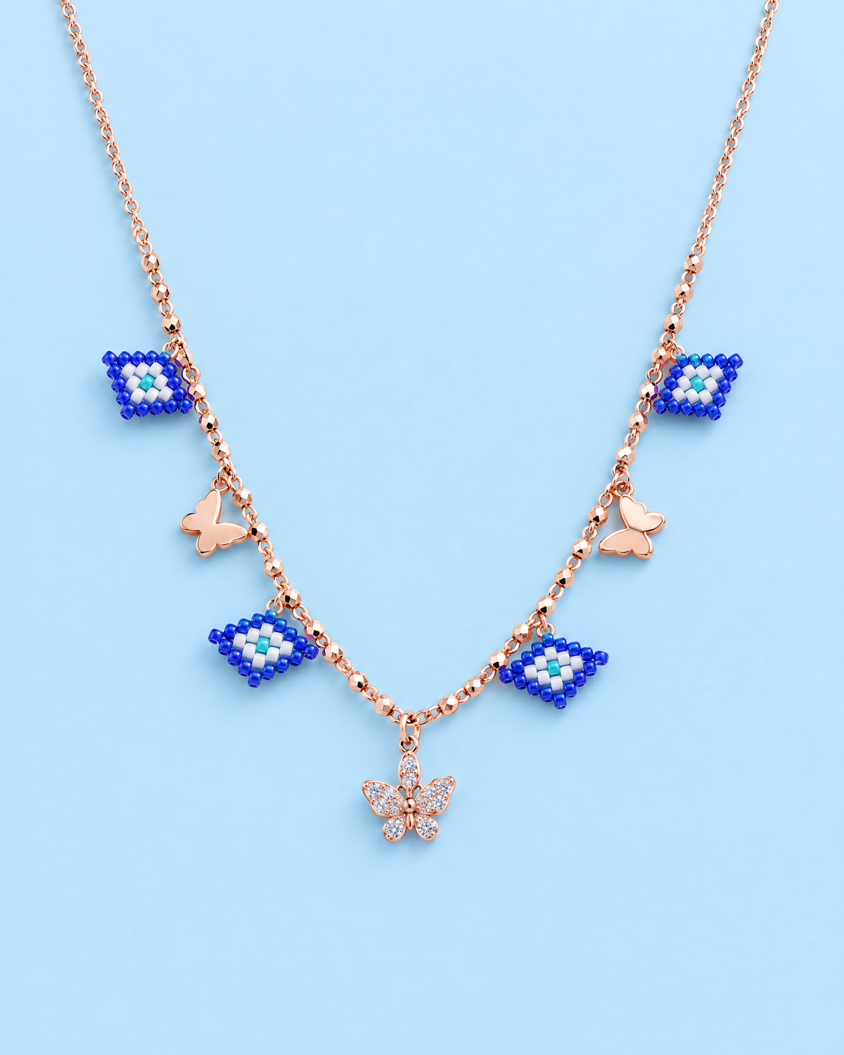 Evil Eye Butterfly Charm Necklace on blue background