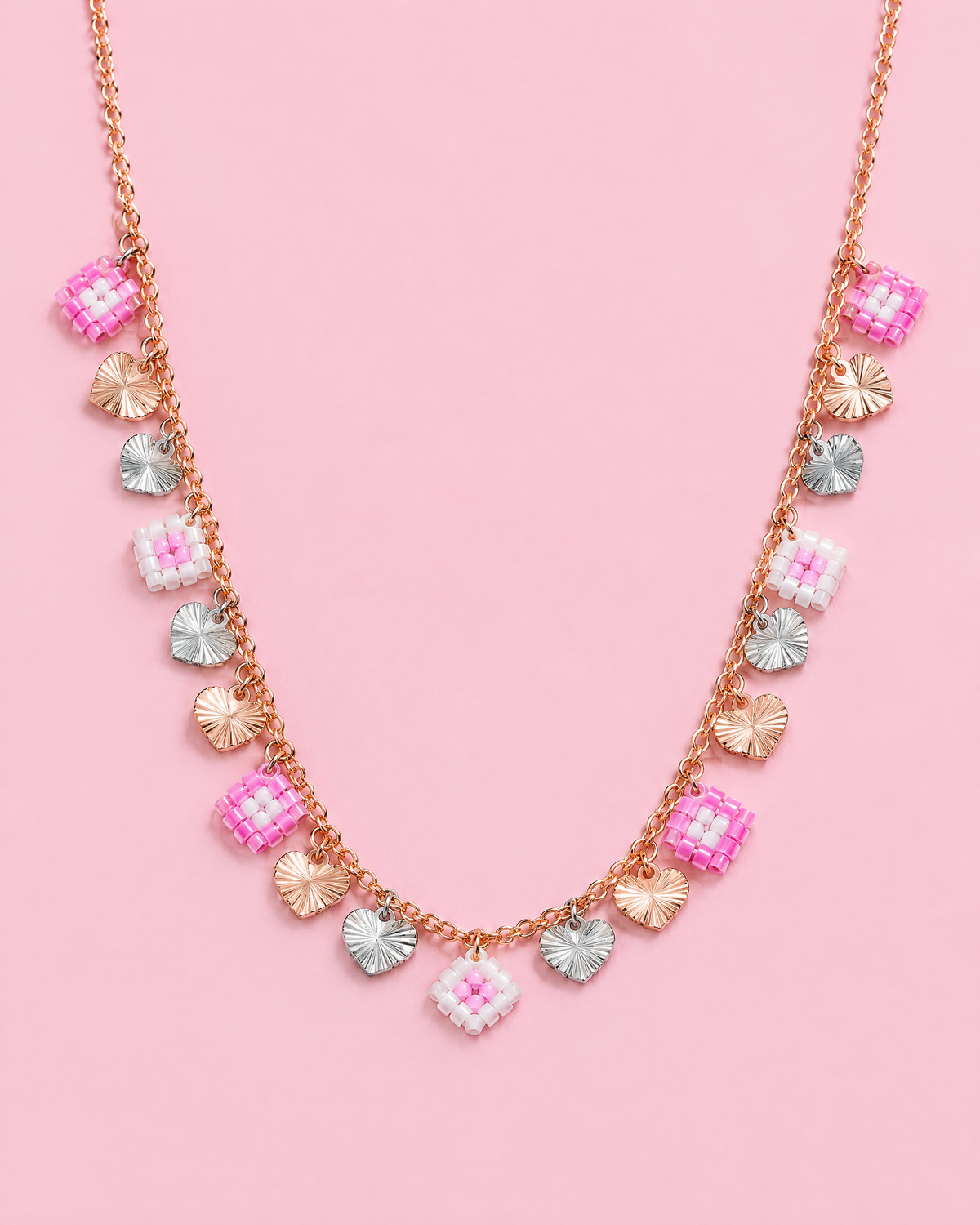 Sunburst Hearts Charm Necklace on pink background