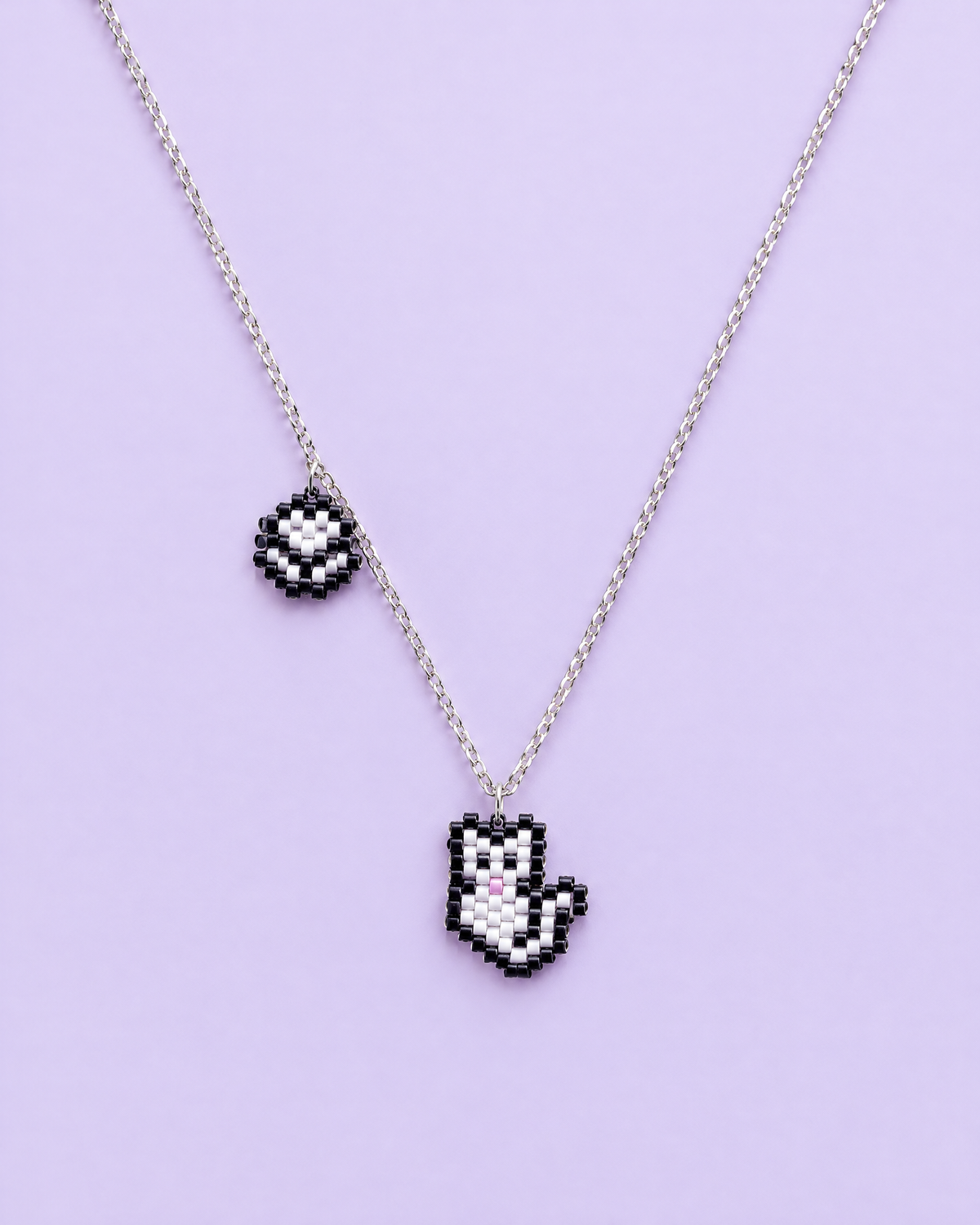 Kitty Paw Charm Necklace on lavender background