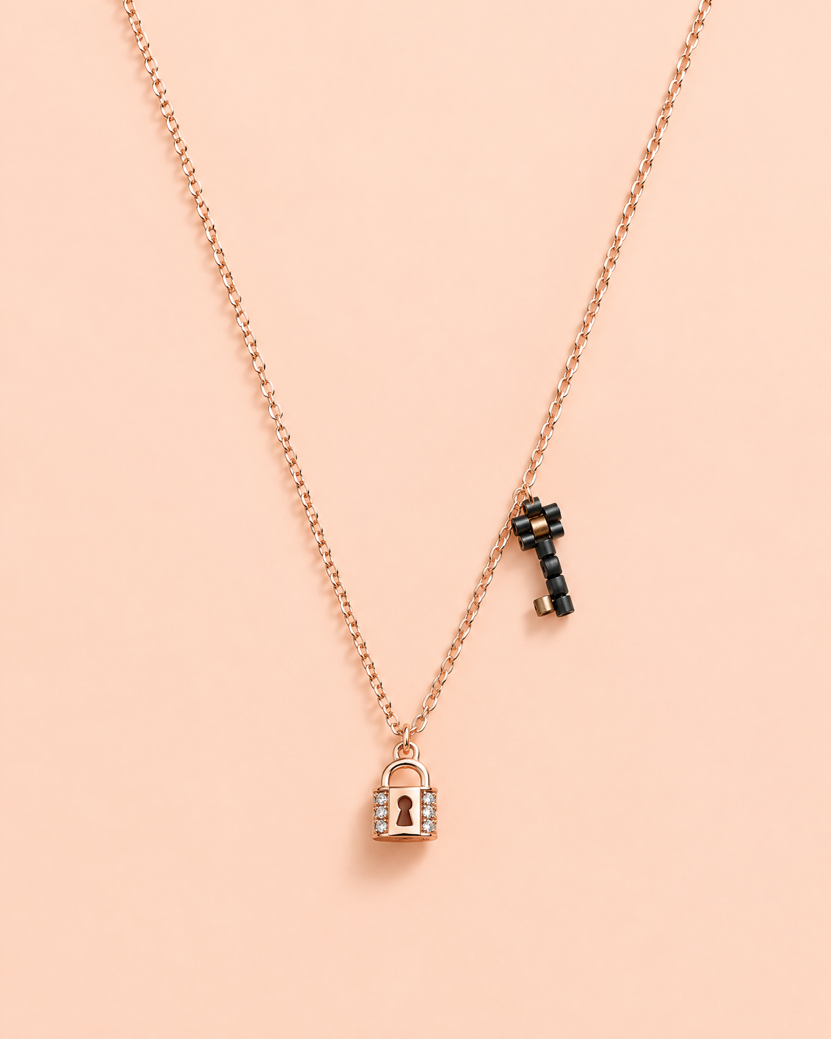 Lock & Key Charm Necklace on peach background