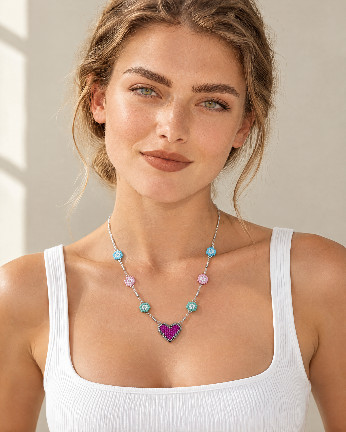 Model wearing the Daisy Heart Charm Necklace with a white tank top