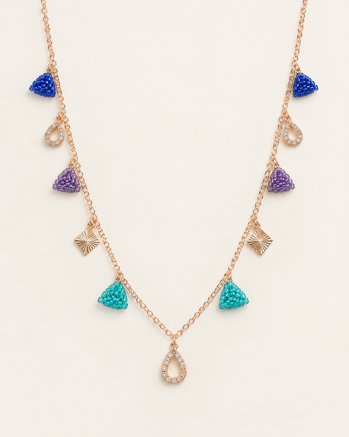 Jewel Triangle Charm Necklace – rose-gold chain with cobalt, purple and turquoise beaded triangles, crystal teardrops and sunburst diamond charms